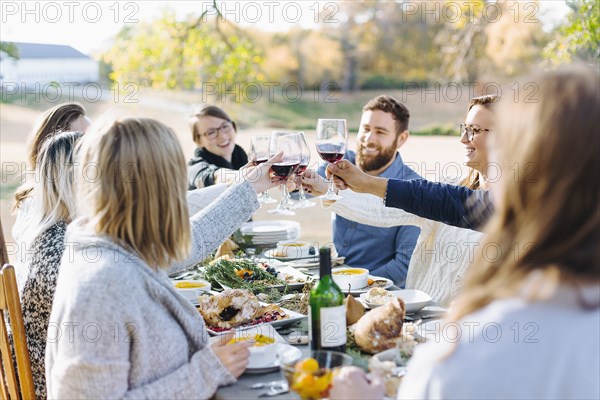 Friends toasting with wine at outdoor table