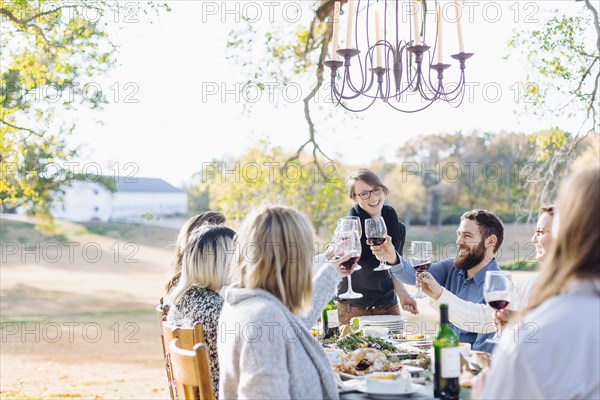 Friends toasting with wine at outdoor table