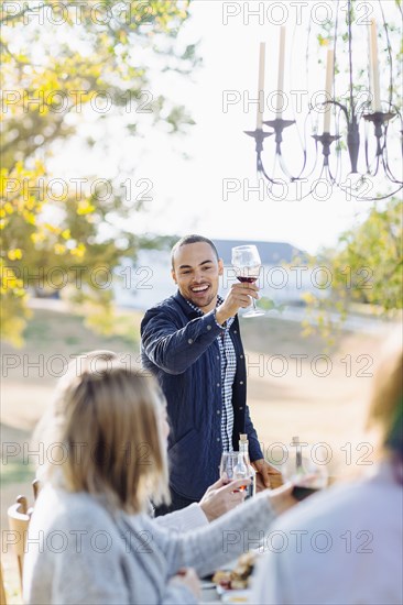Friends toasting with wine at outdoor table