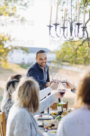 Friends toasting with wine at outdoor table