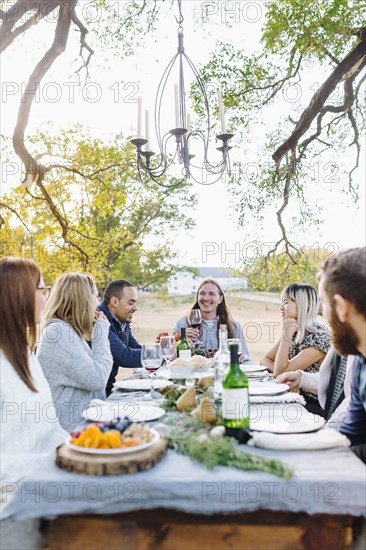 Friends drinking wine at outdoor table