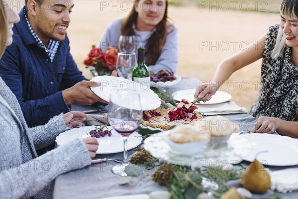 Woman serving pie at outdoor table