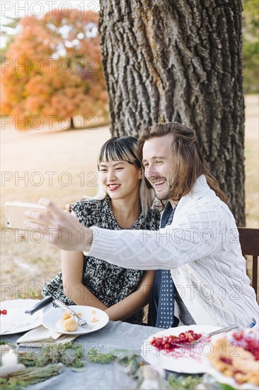 Couple taking selfie at outdoor table