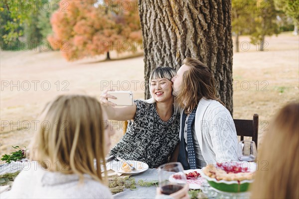 Couple taking selfie at outdoor table