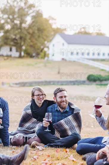 Friends drinking wine in rural field