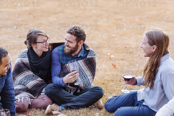 Friends drinking wine in rural field