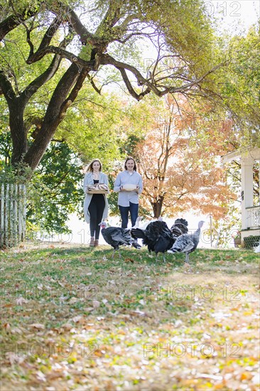 Caucasian couple carrying food in backyard