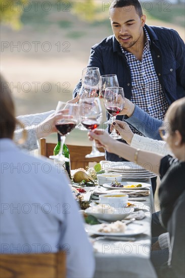 Friends toasting with wine at outdoor table