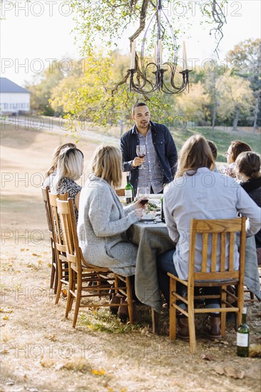 Friends toasting with wine at outdoor table