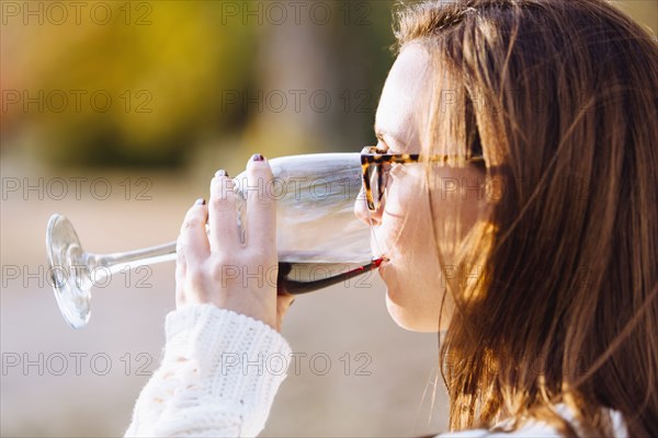 Caucasian woman drinking wine outdoors