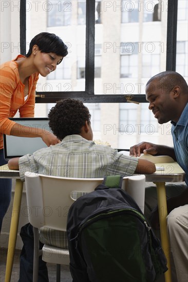 Mother and fathering helping son with homework