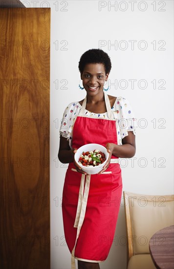 African American woman holding a bowl of salad