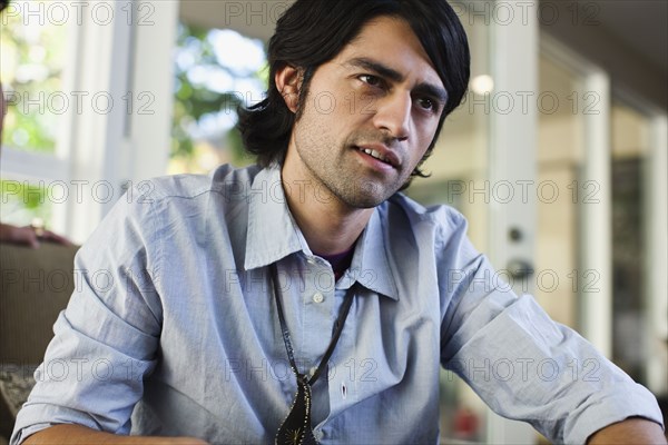 Hispanic man sitting indoors