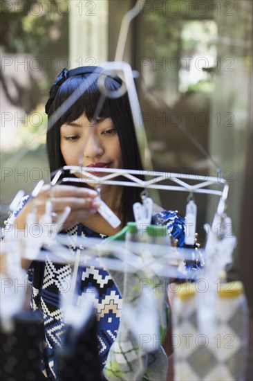 Asian woman hanging laundry out to dry