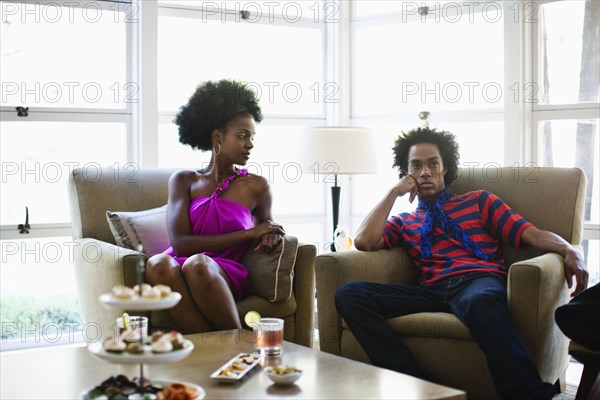 African American woman sitting at cocktail party with boyfriend