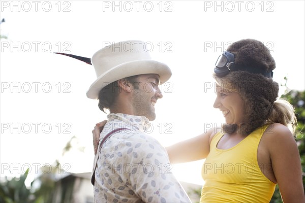 Caucasian couple in funny hats hugging