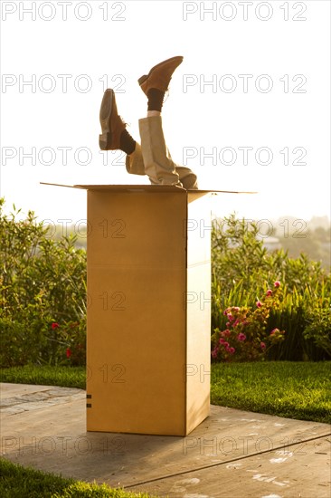 Man upside-down in cardboard box