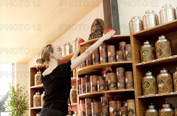 Caucasian woman organizing shelves in shop