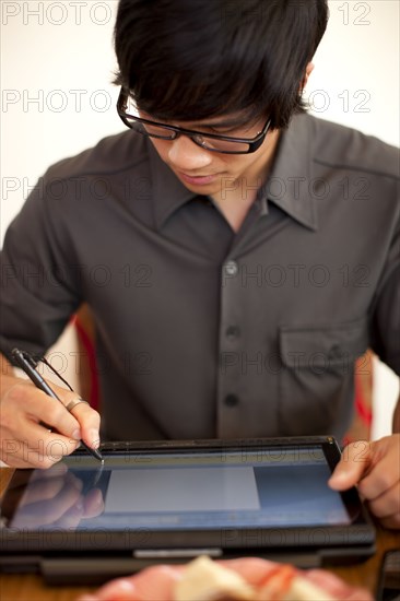 Mixed race man using digital tablet