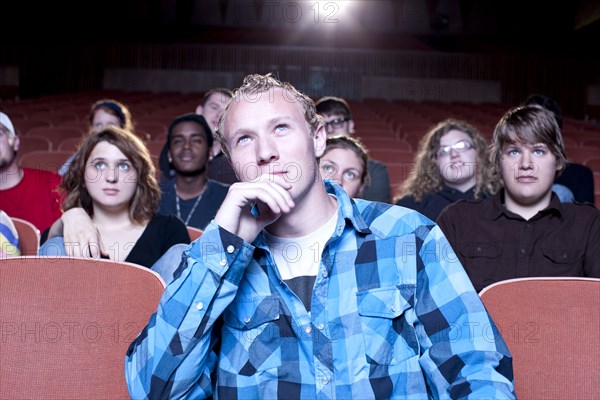 Caucasian man watching movie in theater