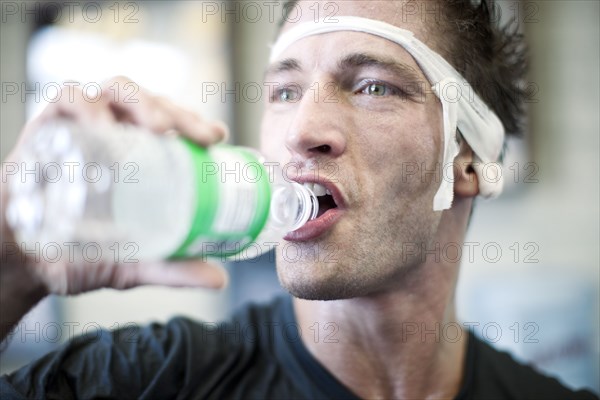 Bandaged man drinking water