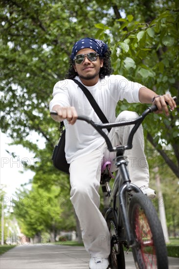 Peruvian man riding bicycle on sidewalk