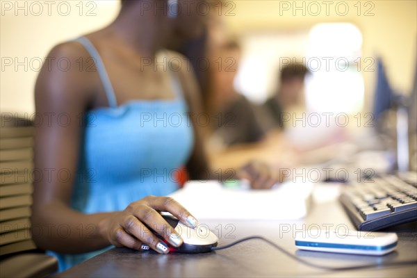 Black student using computer mouse in computer lab
