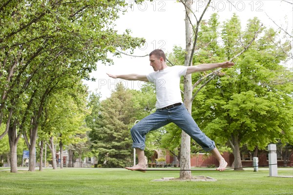 Caucasian man balancing on rope in park