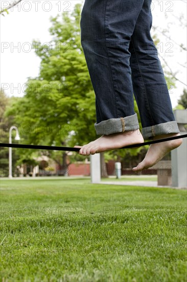 Caucasian man balancing on rope in park