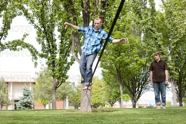 Caucasian man balancing on rope in park