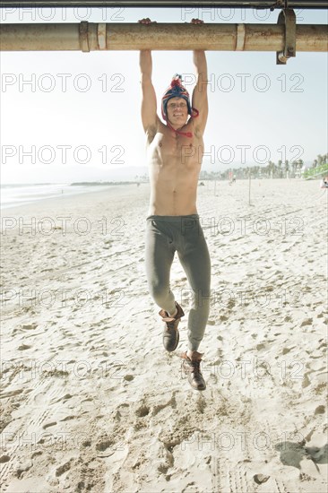 Caucasian man hanging from pipe