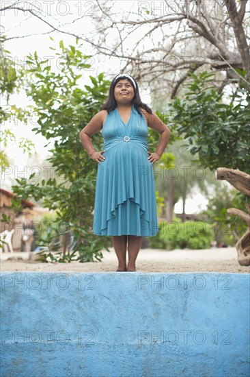 Hispanic woman standing outdoors with hand son hips