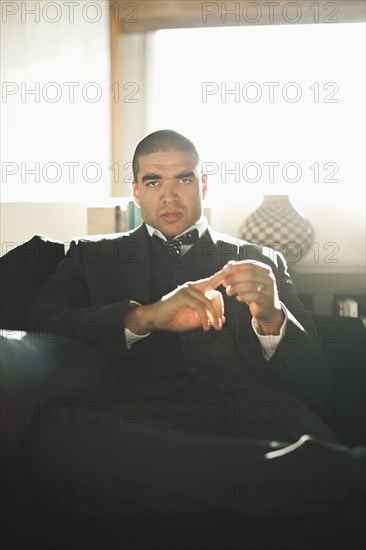 Serious mixed race businessman sitting in chair