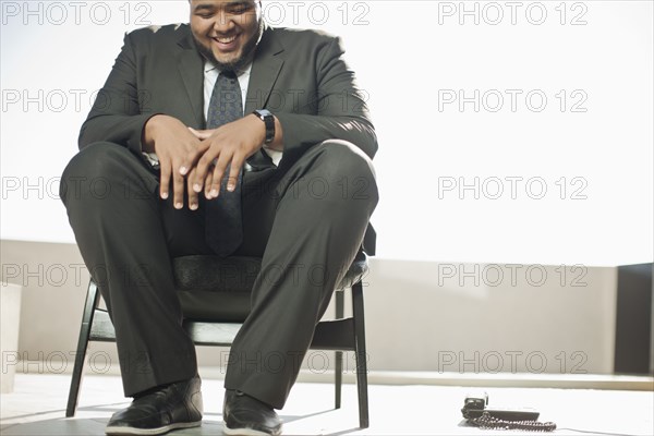 Smiling mixed race businessman sitting on patio