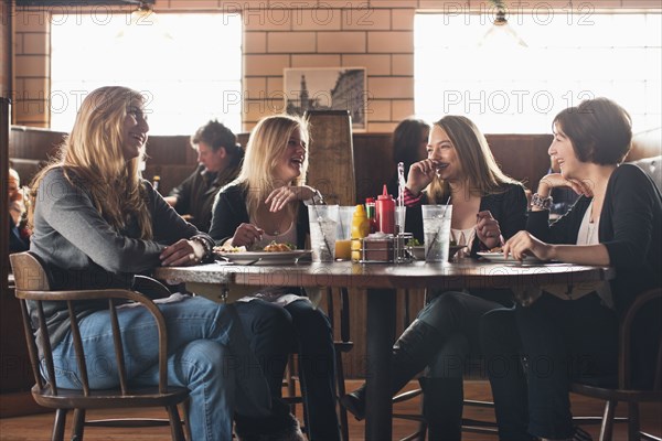 Caucasian teenagers eating together in restaurant