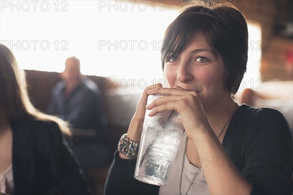 Caucasian teenager drinking water in restaurant