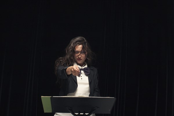 Mixed race conductor pointing baton