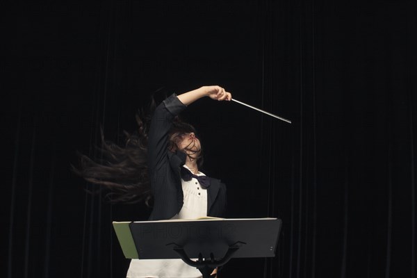 Mixed race conductor pointing baton