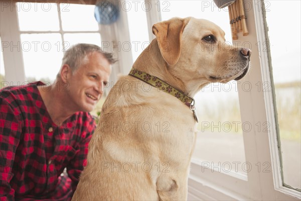 Caucasian man sitting with labrador