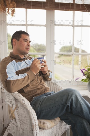 Hispanic man relaxing and drinking coffee