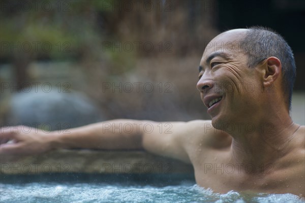 Chinese man relaxing in hot tub