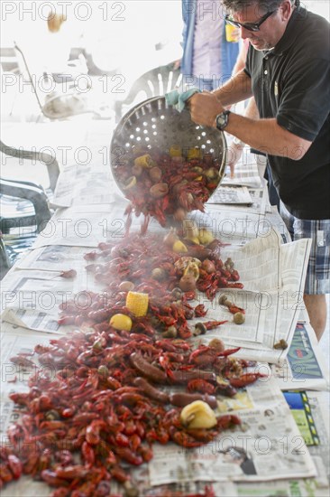 Caucasian man serving crawfish at boil