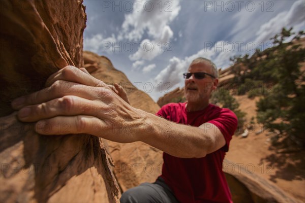 Caucasian rock climber scaling cliff