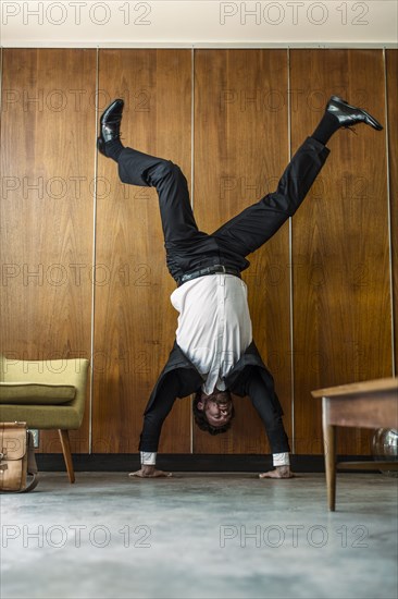 Caucasian businessman doing handstand