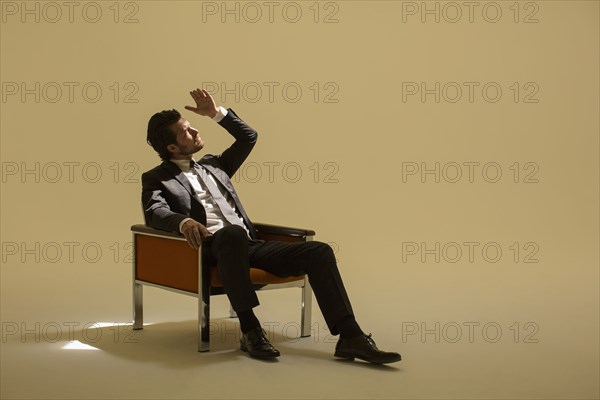 Caucasian businessman sitting under spotlight