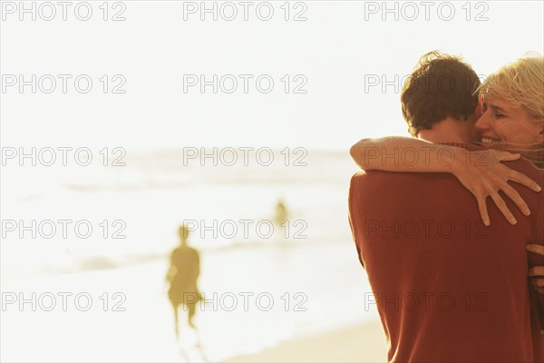 Caucasian couple hugging on beach