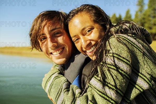 Couple hugging by rural lake