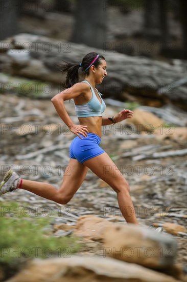Mixed race woman running in woods