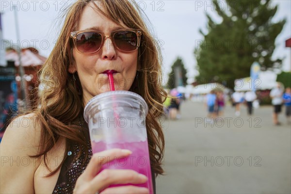 Caucasian woman drinking juice outdoors