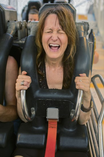 Caucasian woman shouting on roller coaster